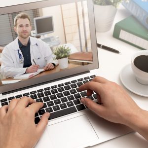 Doctor with a stethoscope on the computer laptop screen. Telemedicine or telehealth concept.